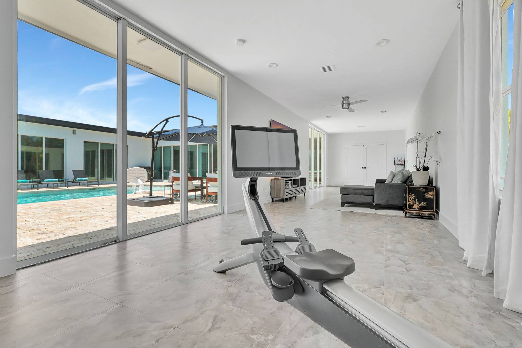 Light-filled Villa Verano event space with glass doors opening to the pool deck