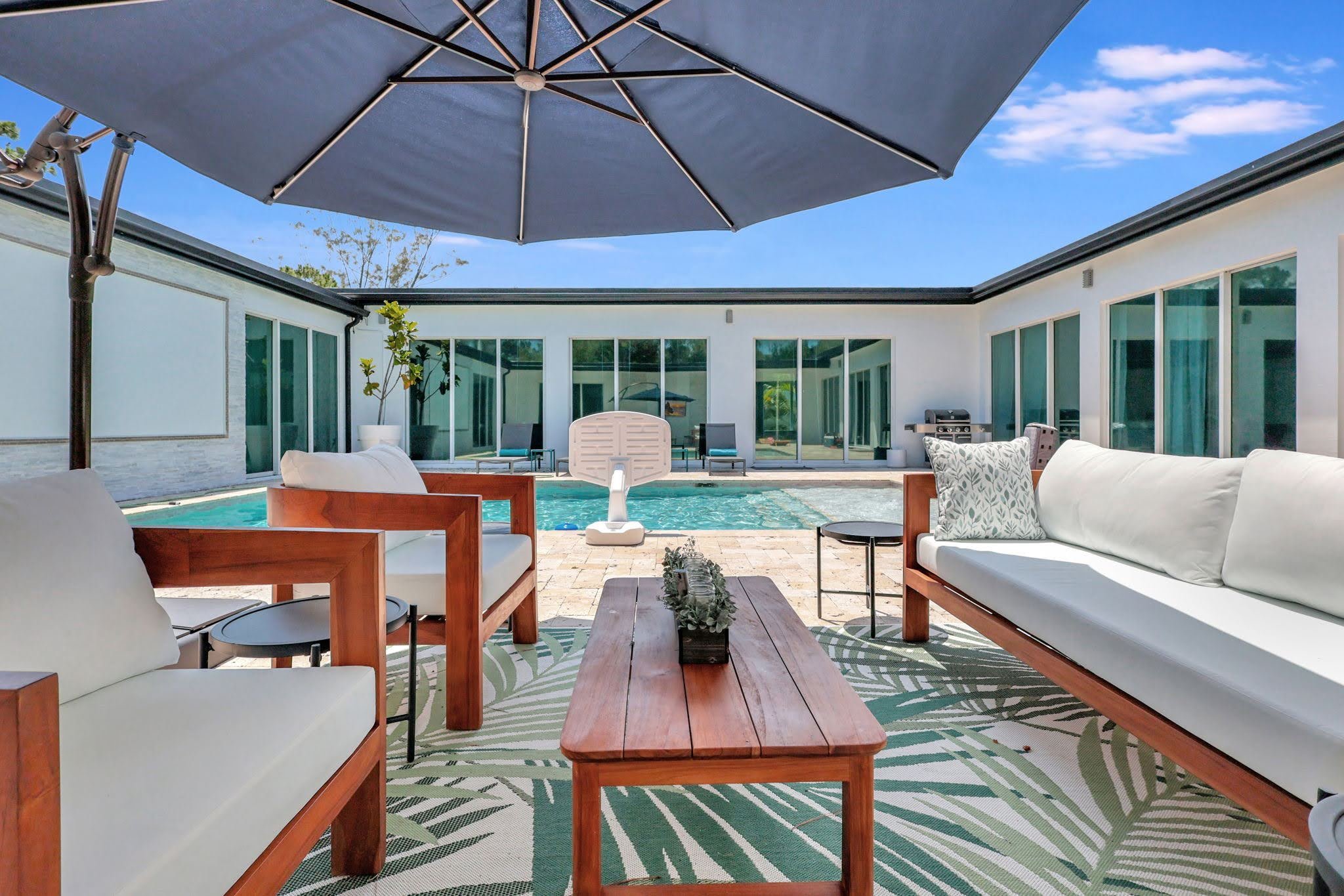 Covered poolside patio lounge at Villa Verano in Loxahatchee with outdoor seating